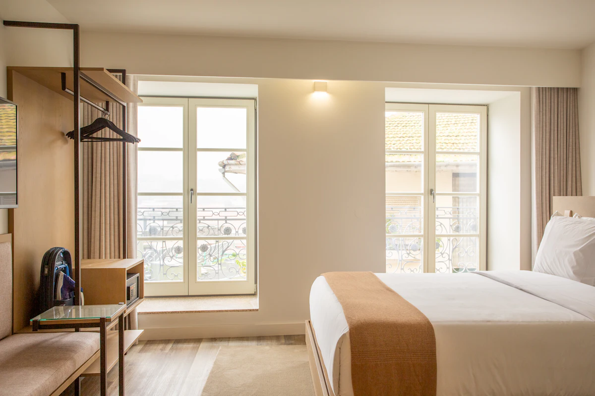 Studio mobiliado com cama de casal e janelas amplas, pronto para locação
