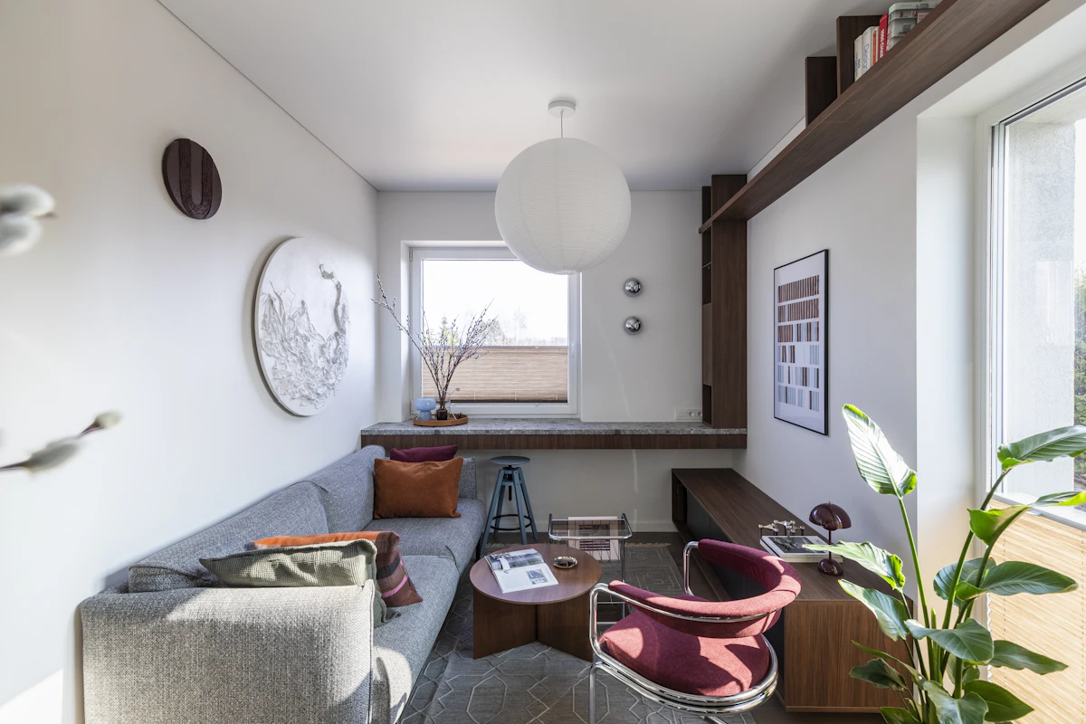 Sala de estar de um studio decorado, com sofá e muita luz natural
